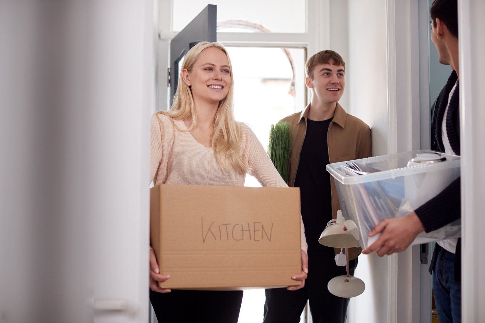 Group Of College Student Carrying Boxes Moving Into Accommodation Together